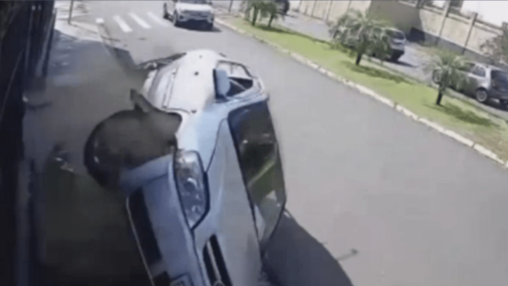 Motorista sem habilitação, passa em sinal vermelho, atropela pedestre na calçada e capota o carro na sequência&nbsp;(vídeo)